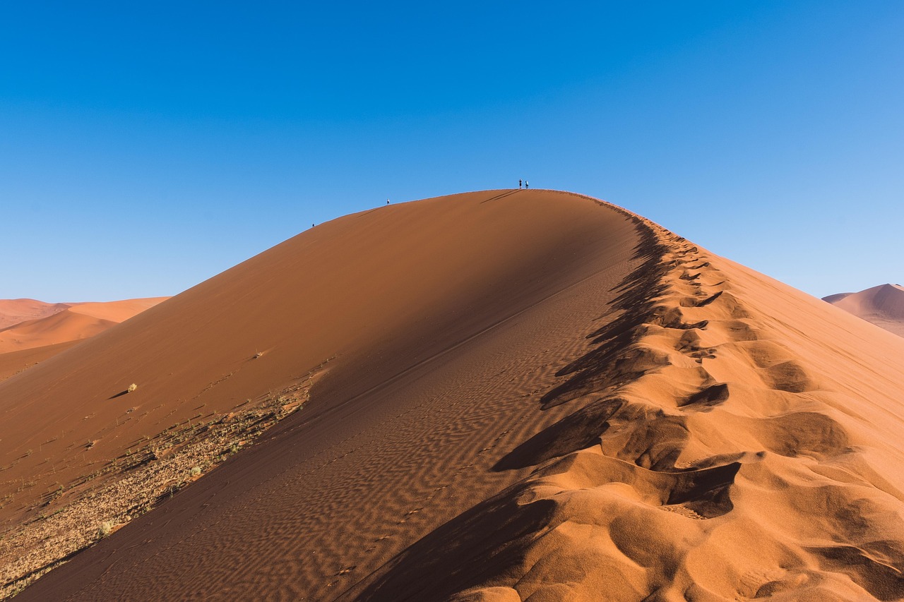 Dramatic orange sand dune against a deep blue sky, Namib Desert, Namibia